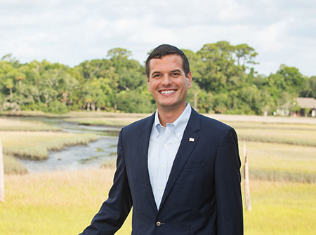 young man in a suit with a marsh in the background
